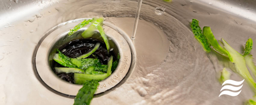 garbage-disposals-101 cucumber peels going down a garbage disposal in the sink