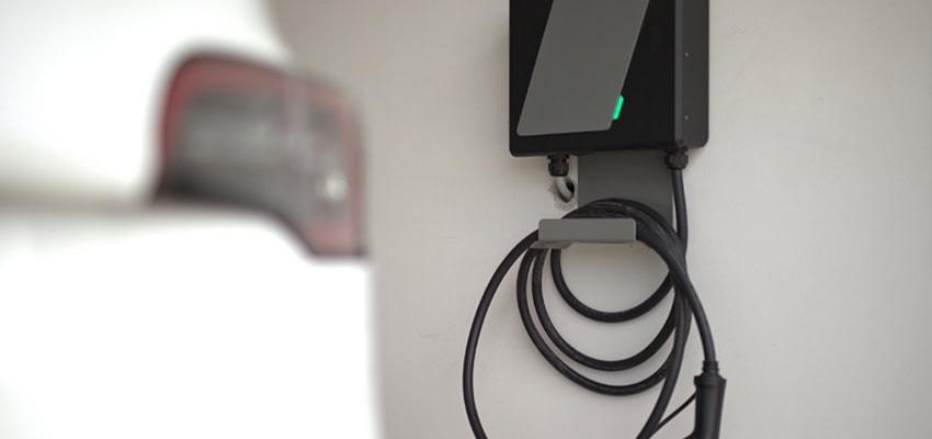 Ev Charger Installation - EV charger and back of car in a private home garage